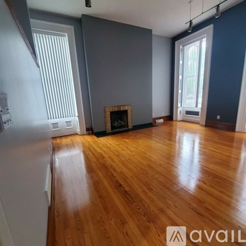 A room with wooden floors and a fireplace.
