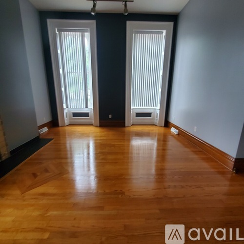 A room with wooden floors and two doors.