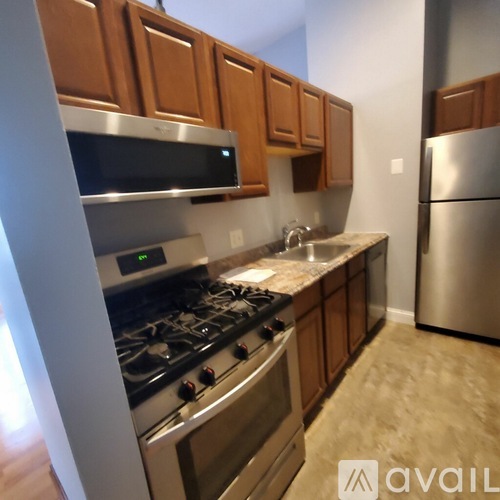 A kitchen with wooden cabinets and a stainless steel refrigerator.