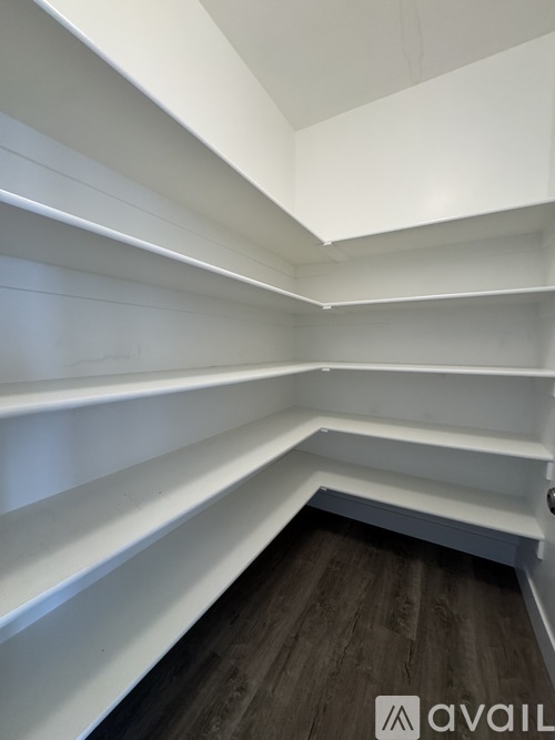 A white shelving unit with a logo on the bottom right.