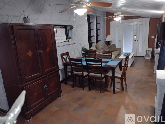 A dining room with a wooden table and chairs.