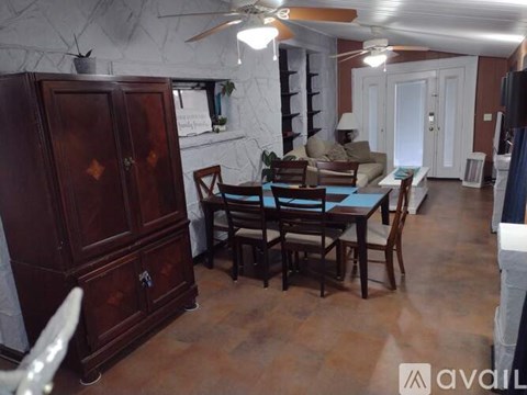 A dining room with a wooden table and chairs.
