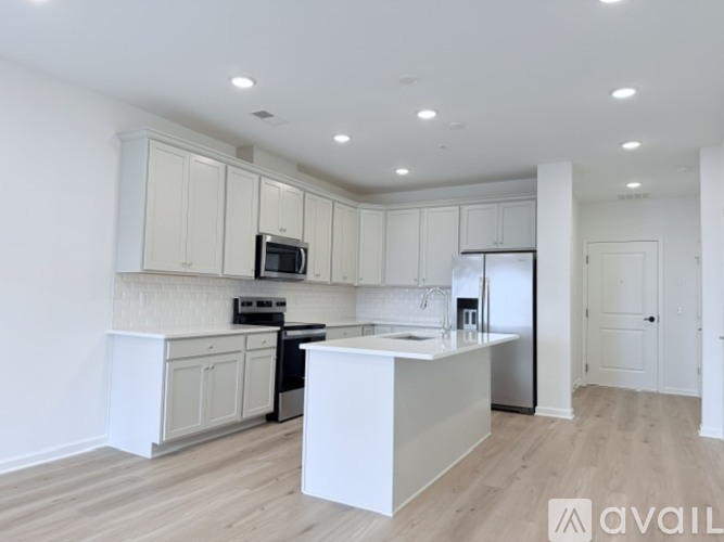 A kitchen with white cabinets and a white island.