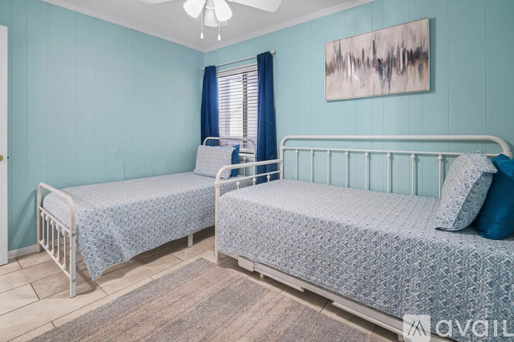 Two twin beds in a room with blue walls.