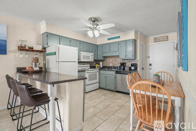 A kitchen with a table and chairs.