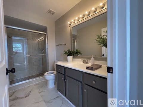 A bathroom with a marble floor and a large mirror above the sink.