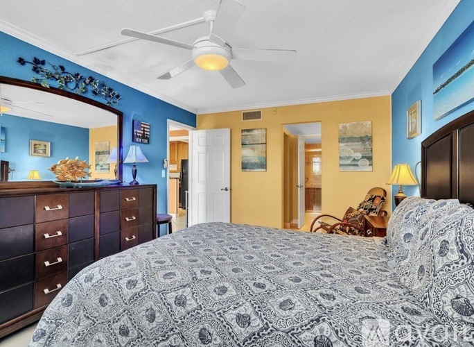 A bedroom with a bed, dresser, and ceiling fan.