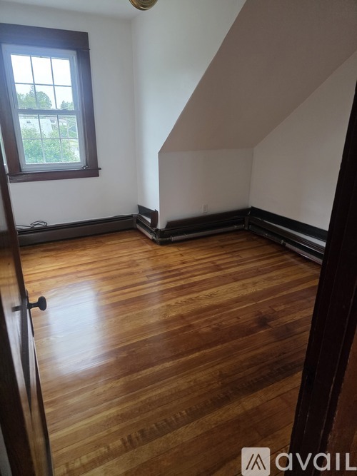 A room with wooden flooring and a window.