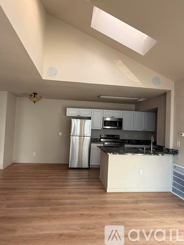 A kitchen with a refrigerator, microwave, and oven.