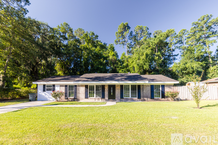 A house with a green lawn and trees in the background.