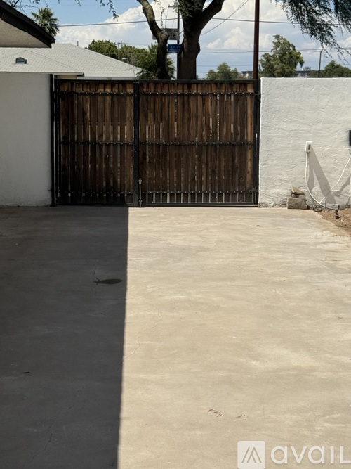 A wooden gate blocks the entrance to a driveway.