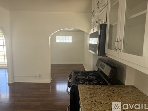 A kitchen with a stove top oven and cabinets.