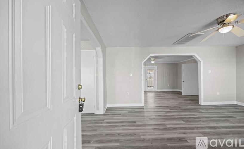 A room with a white door and a fan on the ceiling.