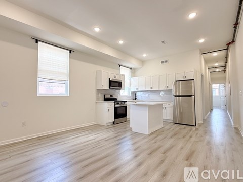 A spacious kitchen with white cabinets and stainless steel appliances.