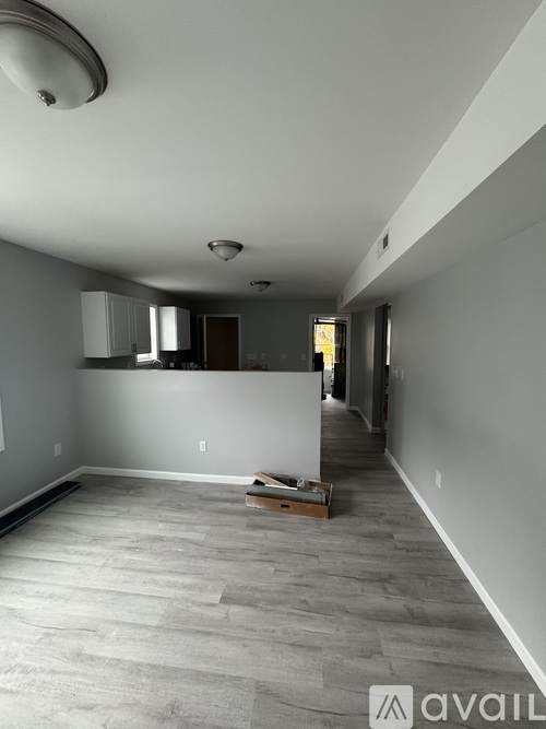 A room with a grey carpet and white walls is available for rent.
