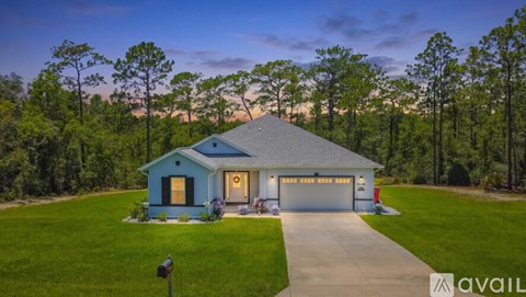 A blue house with a garage is available for sale.