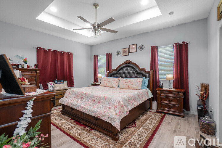 A bedroom with a large bed and a ceiling fan.