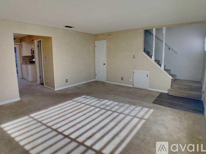 A room with a carpet and a staircase.
