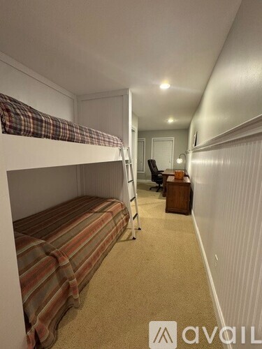 A room with bunk beds and a desk.