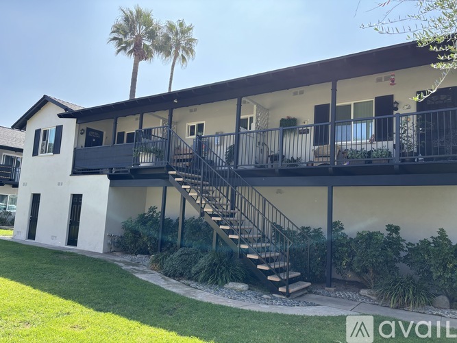 A house with a balcony and stairs leading to it.
