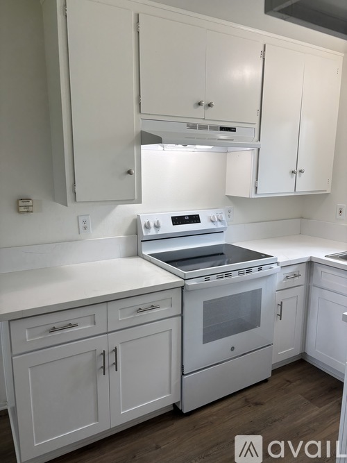 A white kitchen with a stove and cabinets.