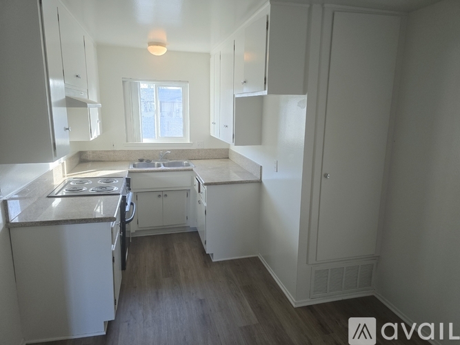 A kitchen with white appliances and cabinets.