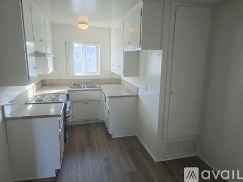 A kitchen with white appliances and cabinets.