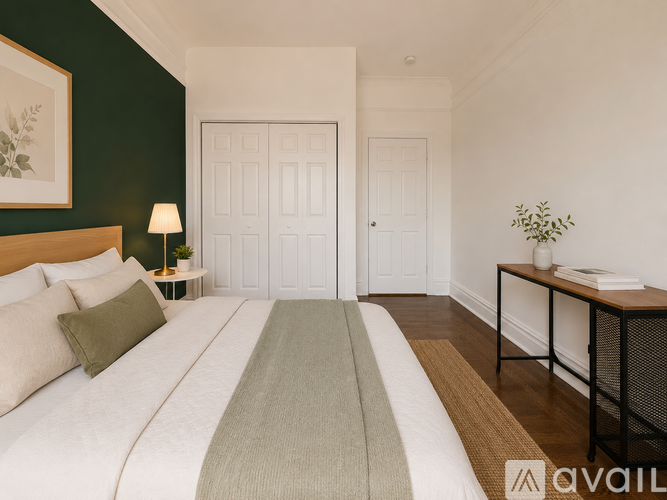 A bedroom with a large bed and a green headboard.