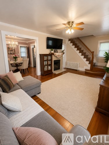 A living room with a grey couch and a white rug.