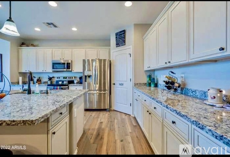 A kitchen with white cabinets and a granite countertop.