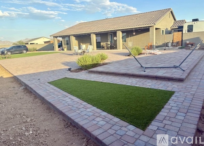 A house with a patio and a lawn in front.