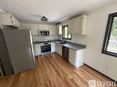 A kitchen with wooden floors and a refrigerator.