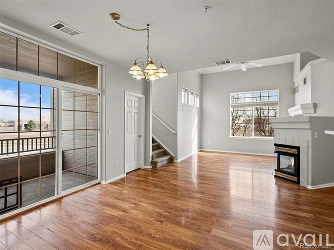 A well-lit, spacious living room with hardwood floors and a fireplace.