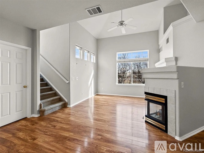 A living room with a fireplace and a staircase.