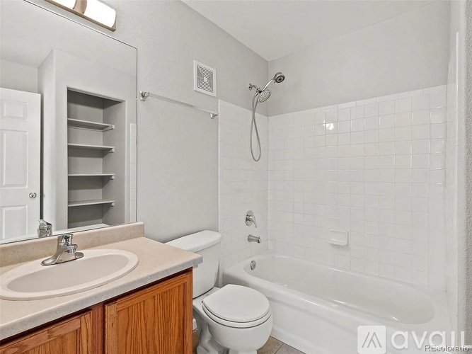 A bathroom with a white tub, sink, and toilet.