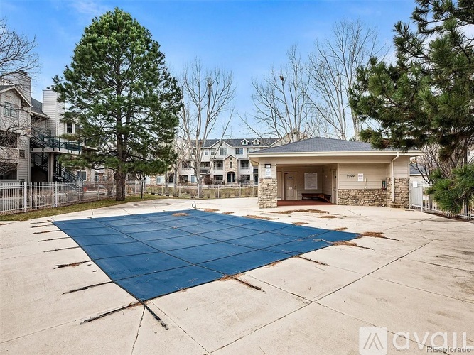 A blue tarp covers a concrete surface in front of a building.