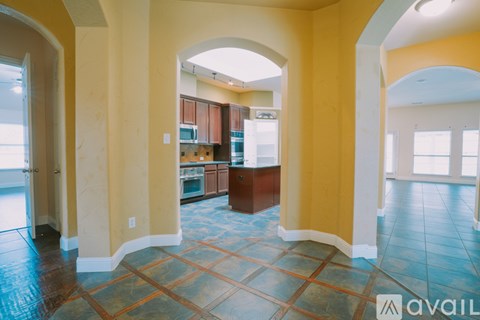 A kitchen area with a tile floor and a yellow wall.