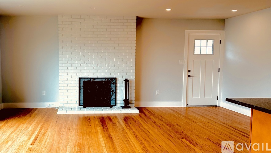 A living room with a fireplace and a wooden floor.