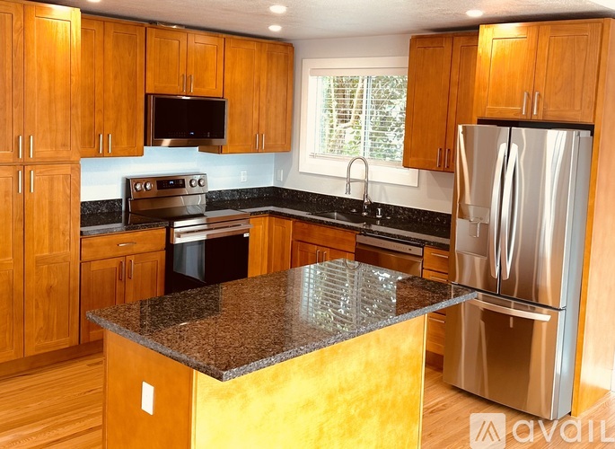 A kitchen with wooden cabinets and a granite countertop.