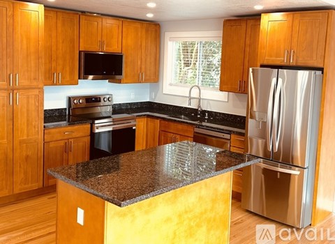 A kitchen with wooden cabinets and a granite countertop.