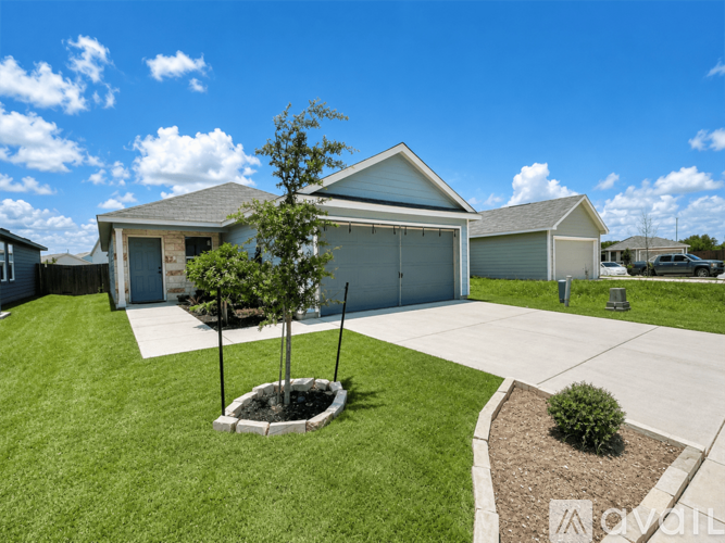 A house with a garage and a tree in the front yard.