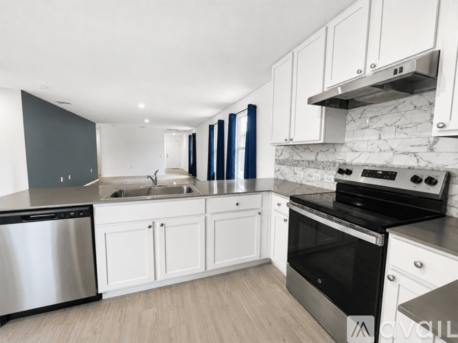 A modern kitchen with white cabinets and stainless steel appliances.