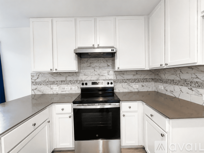 A kitchen with white cabinets and a black stove top oven.