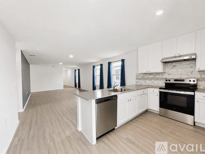 A modern kitchen with white cabinets and stainless steel appliances.