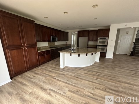 A kitchen with wooden cabinets and a white island.