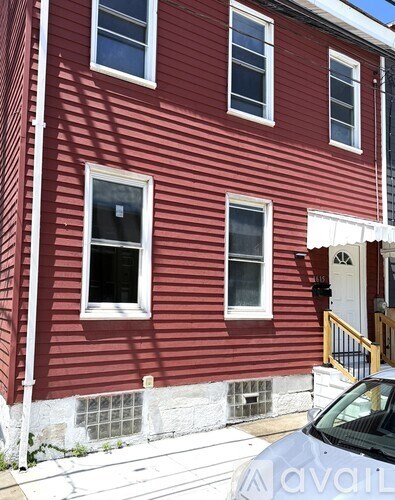 A red building with three windows and a white door.