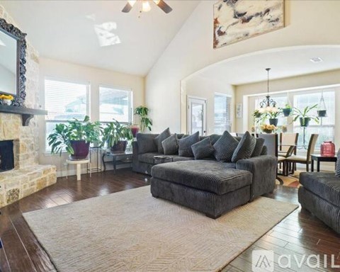 A living room with a grey sofa and a fireplace.