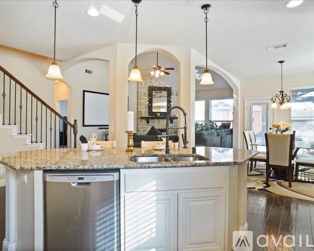 A kitchen with a marble countertop and a sink under a chandelier.