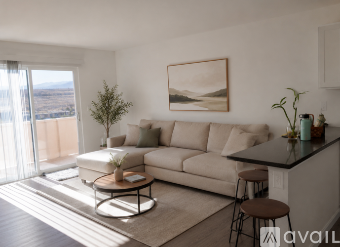 A living room with a beige couch, a coffee table, and a painting on the wall.