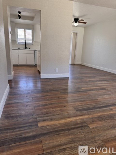 A room with wooden flooring and a ceiling fan.